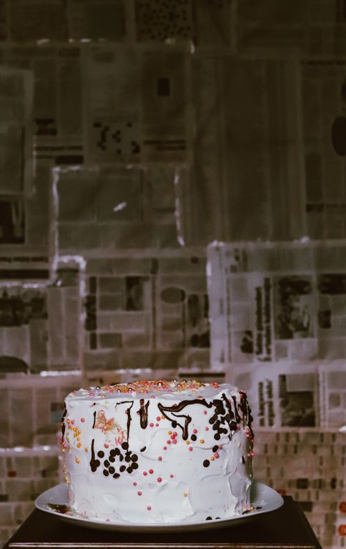 Free Tasty cake with a white frosting and chocolate drizzle, perfectly captured in an urban setting. Stock Photo