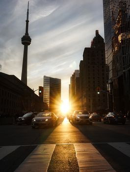 Stunning urban view of Toronto skyline during sunset, featuring the iconic CN Tower and busy streets.