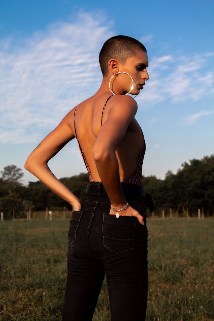A Woman With A Buzz Cut In A Backless Outfit