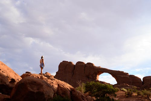 A Woman Standing on Brown Rock Formation