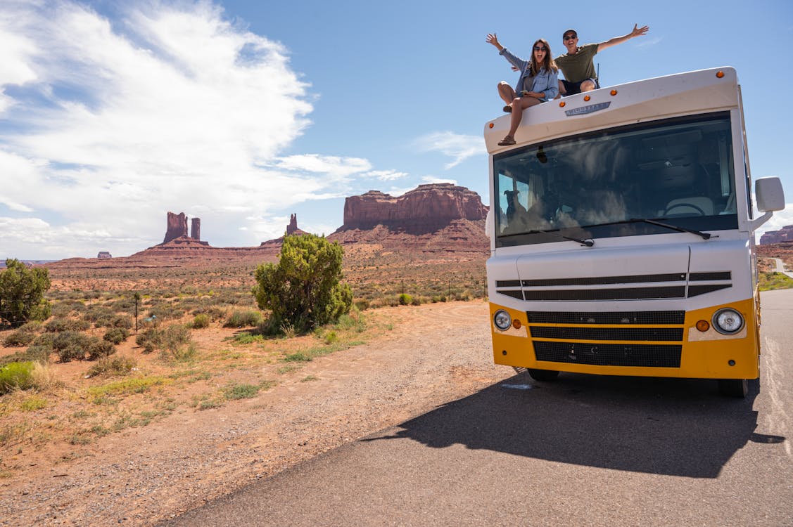 Free Couple Sitting on Top of the RV Stock Photo