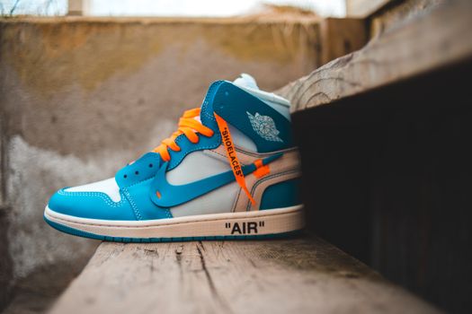 Modern sneaker on wooden surface on street