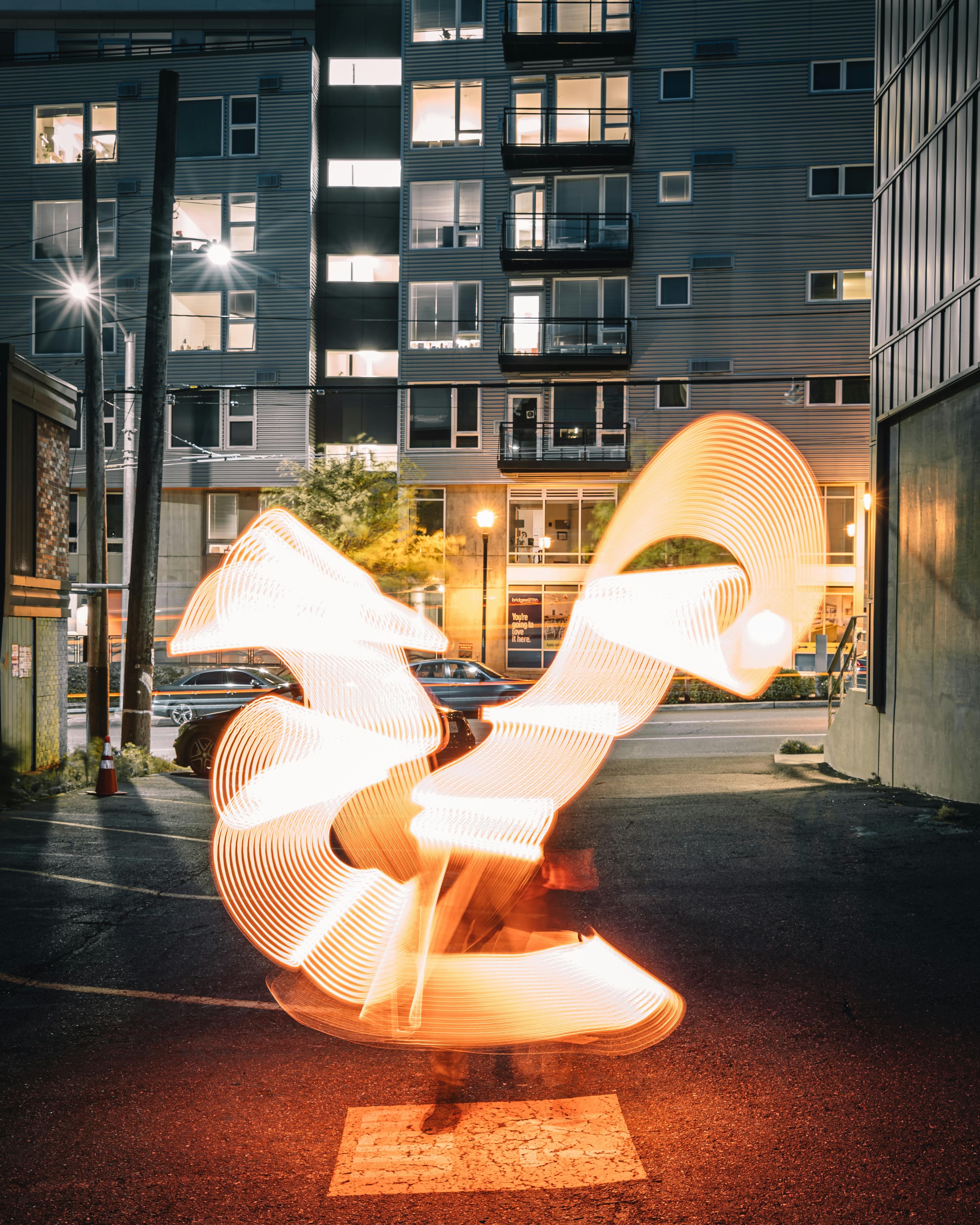 Luminous light in long exposure in dark evening city street with concrete houses