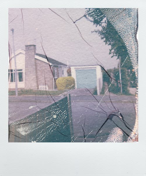 Polaroid Photo of Suburban House Behind Broken Window