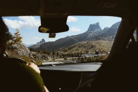 Experience the breathtaking view of the Dolomites through a car windshield, highlighting the adventure of a road trip.