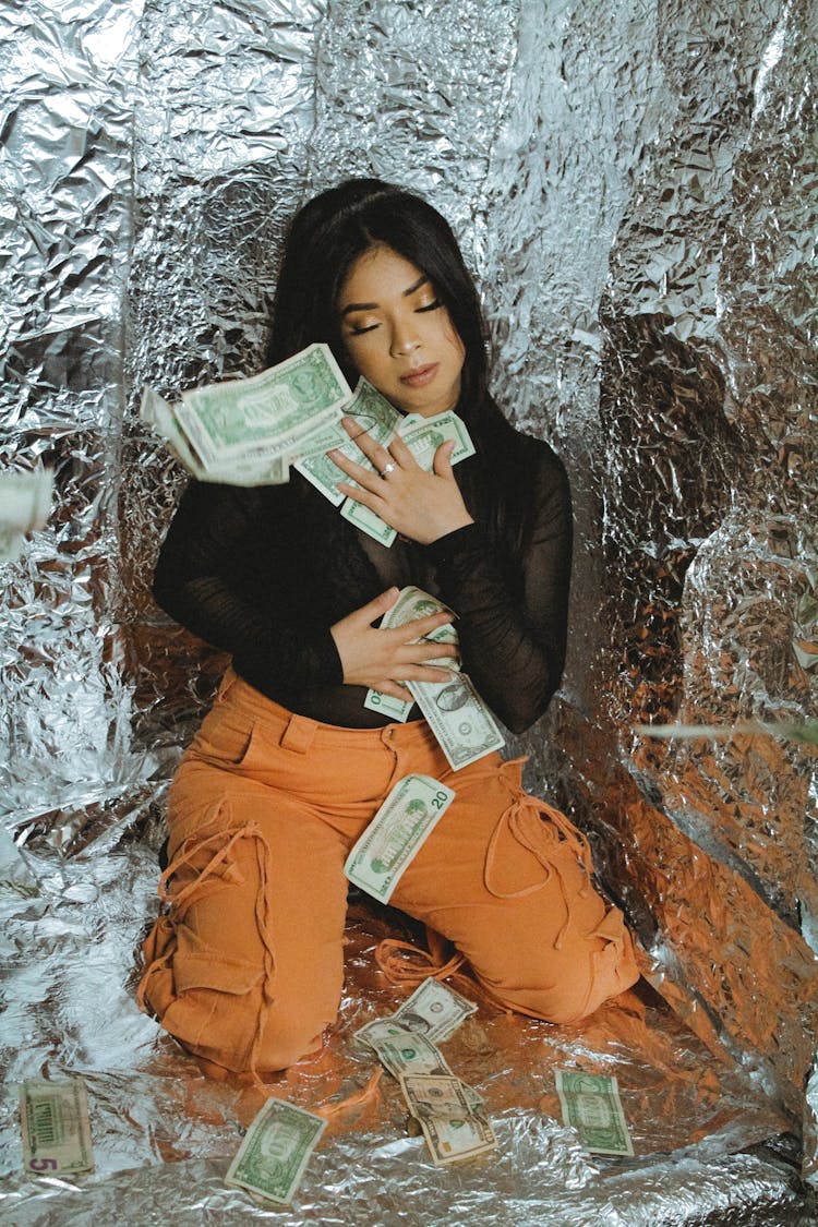 Young Woman With Money Sitting On Floor