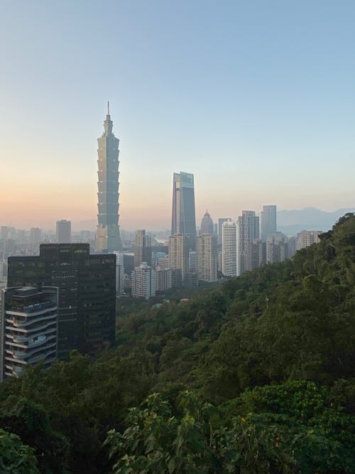 Free Cityscape with modern skyscrapers against green hill Stock Photo