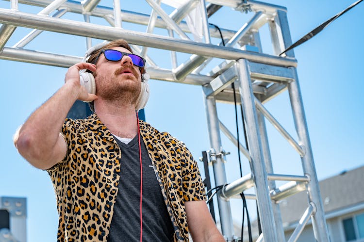 Positive Confident Male DJ In Headphones Performing On Outdoors Stage