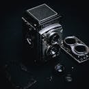 Vintage disassembled photo camera on black surface