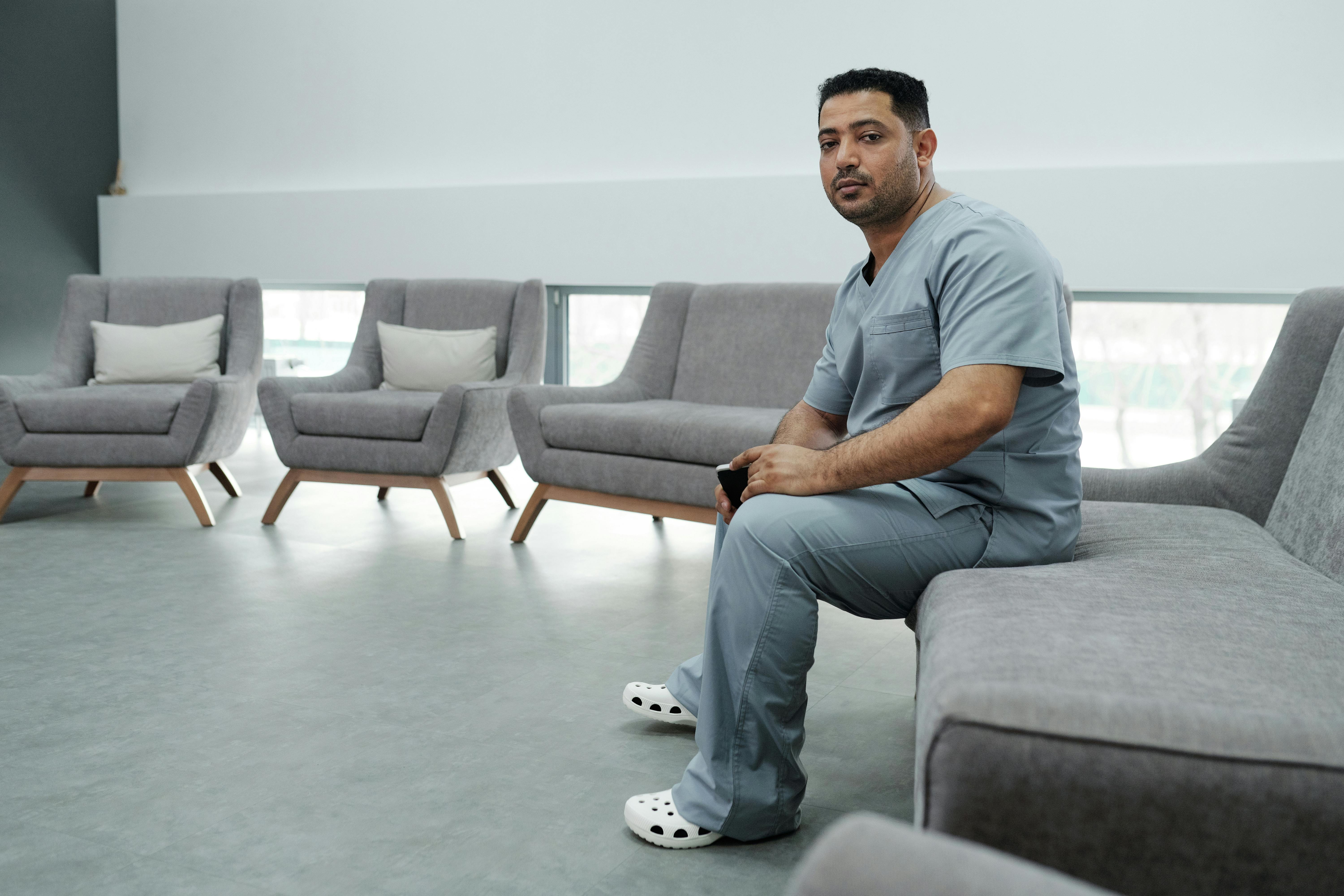 A healthcare professional looking thoughtful and a bit tired, but sitting in a clean, modern, and calm environment, perhaps a quiet break room or home office. The lighting is soft and natural. - What treatment strategies work best for healthcare professionals?