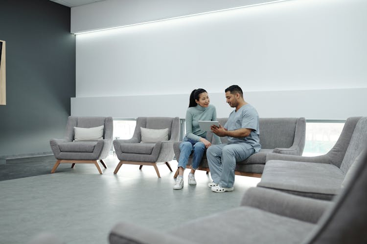 A Doctor Talking To A Patient While Holding A Tablet