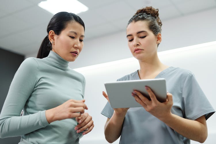 A Doctor And A Patient Looking At A Tablet