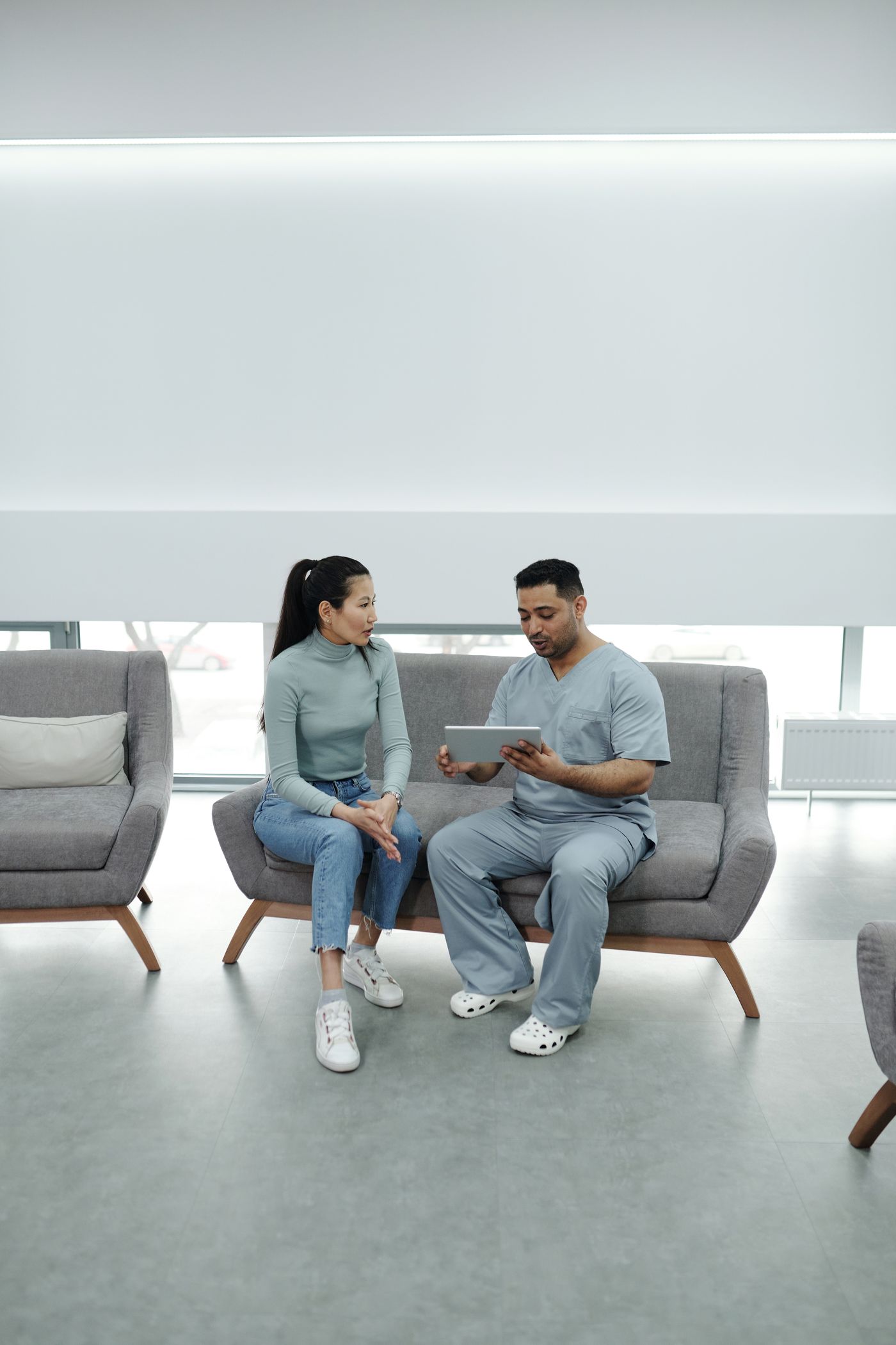 Doctor reviewing results with a patient on a tablet in a modern clinic