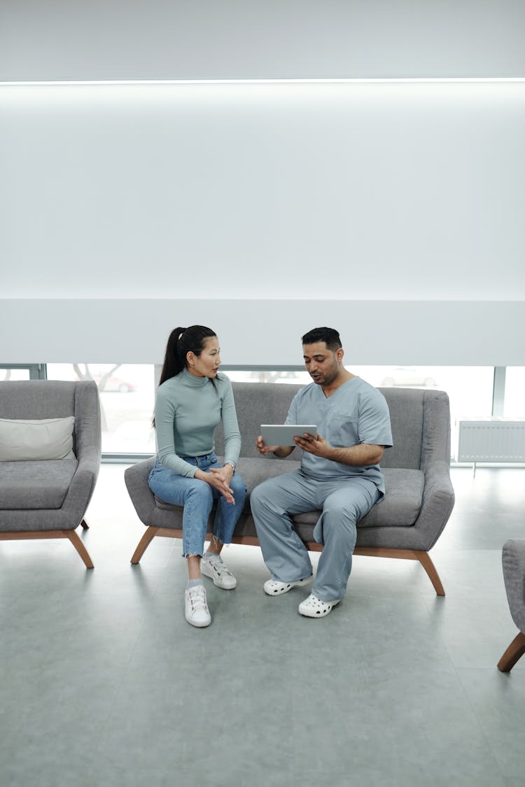 A Doctor Showing A Tablet To A Patient