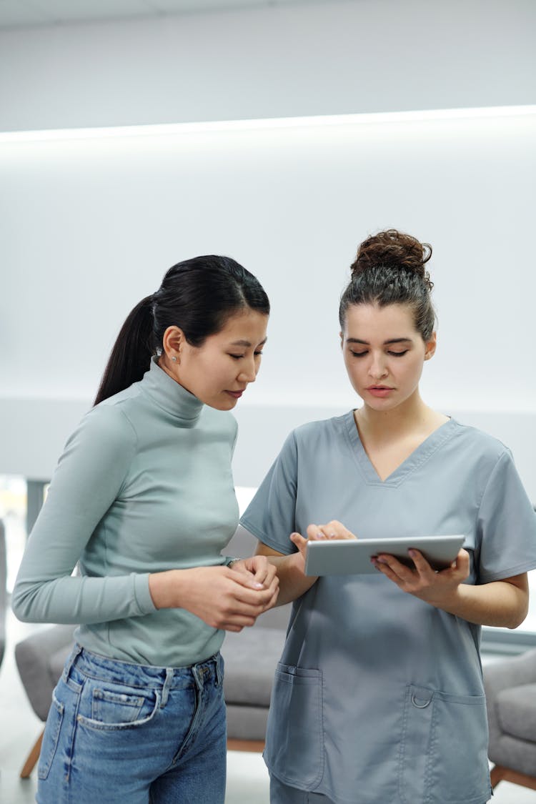 A Doctor And A Patient Looking At A Tablet