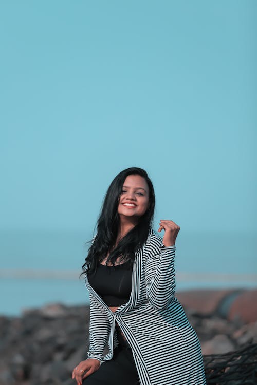 Joyful stylish ethnic woman on seashore