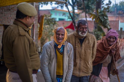 Free A heartwarming scene of elderly Indian people smiling with a police officer outdoors. Stock Photo
