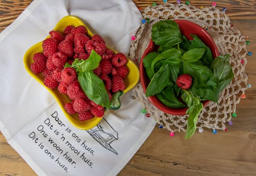 Overhead Shot of Raspberries and a Bowl of Basil Leaves