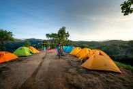 Campground with colorful tents placed on top of mountain in picturesque highlands on sunny day