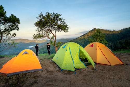 Unrecognizable hikers resting in campsite in mountain valley