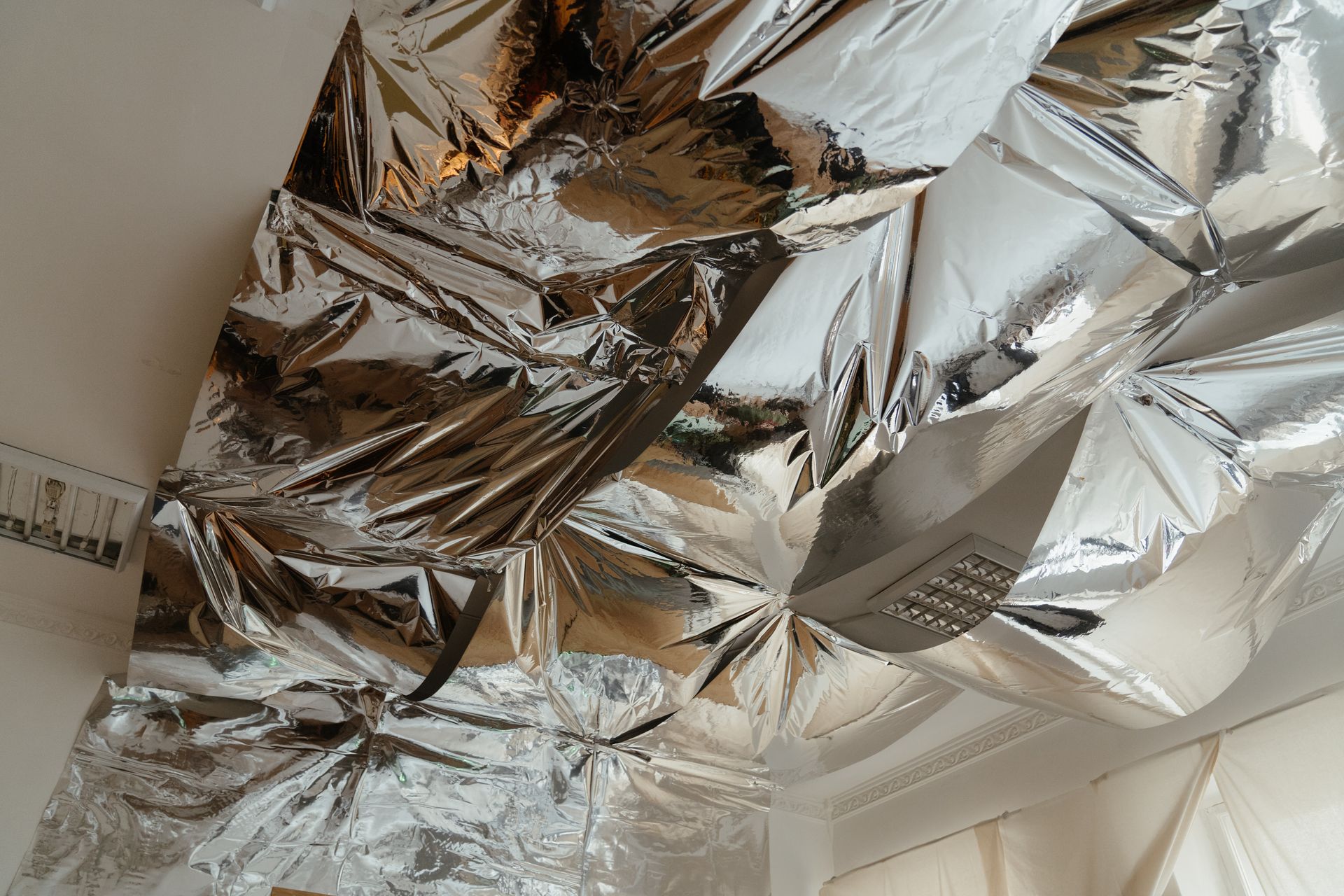 Abstract view of a ceiling covered with metallic reflective foil.