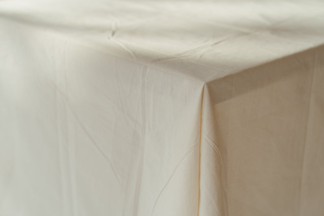 White Textile on Brown Wooden Table