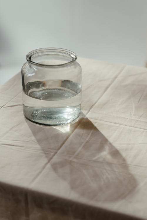 Free Clear Glass Jar on White Textile Stock Photo