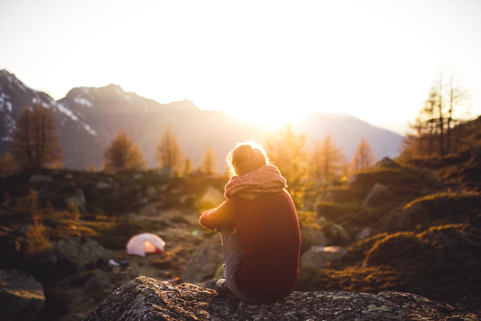 Person Sitting on Rock at Golden Hour