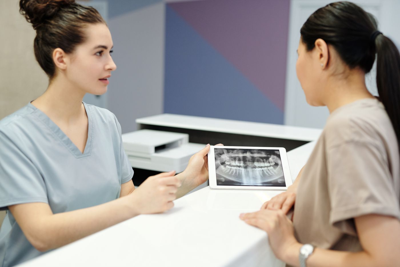 Dentiste présentant une radiographie dentaire à une patiente