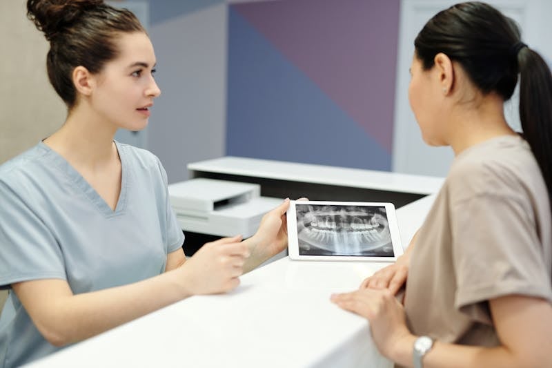 Dentist showing X-ray to patient