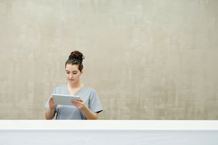 A Receptionist Looking At A Tablet