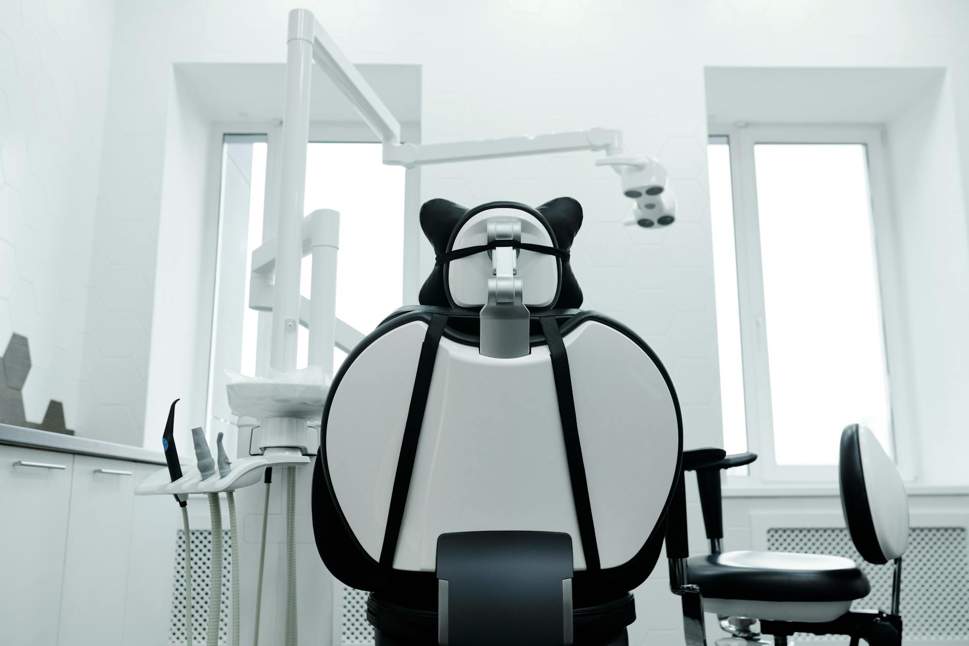 Stylish and modern dentist office with dental chair and equipment in a well-lit setting.