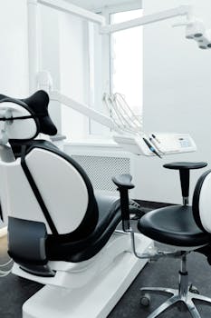 A modern dental chair and equipment setup in a bright, clean dental clinic.