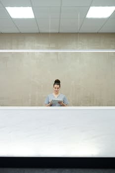A professional receptionist at a sleek modern front desk, focused on her work.