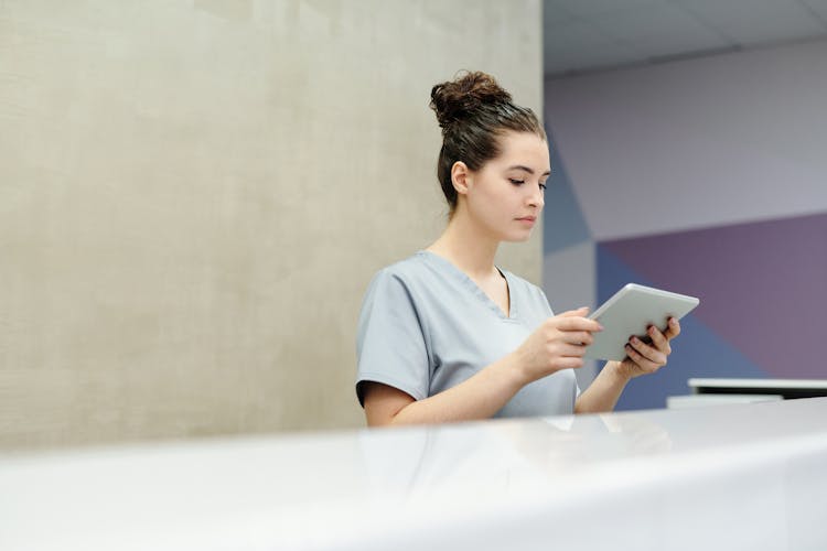 A Receptionist Looking At A Tablet
