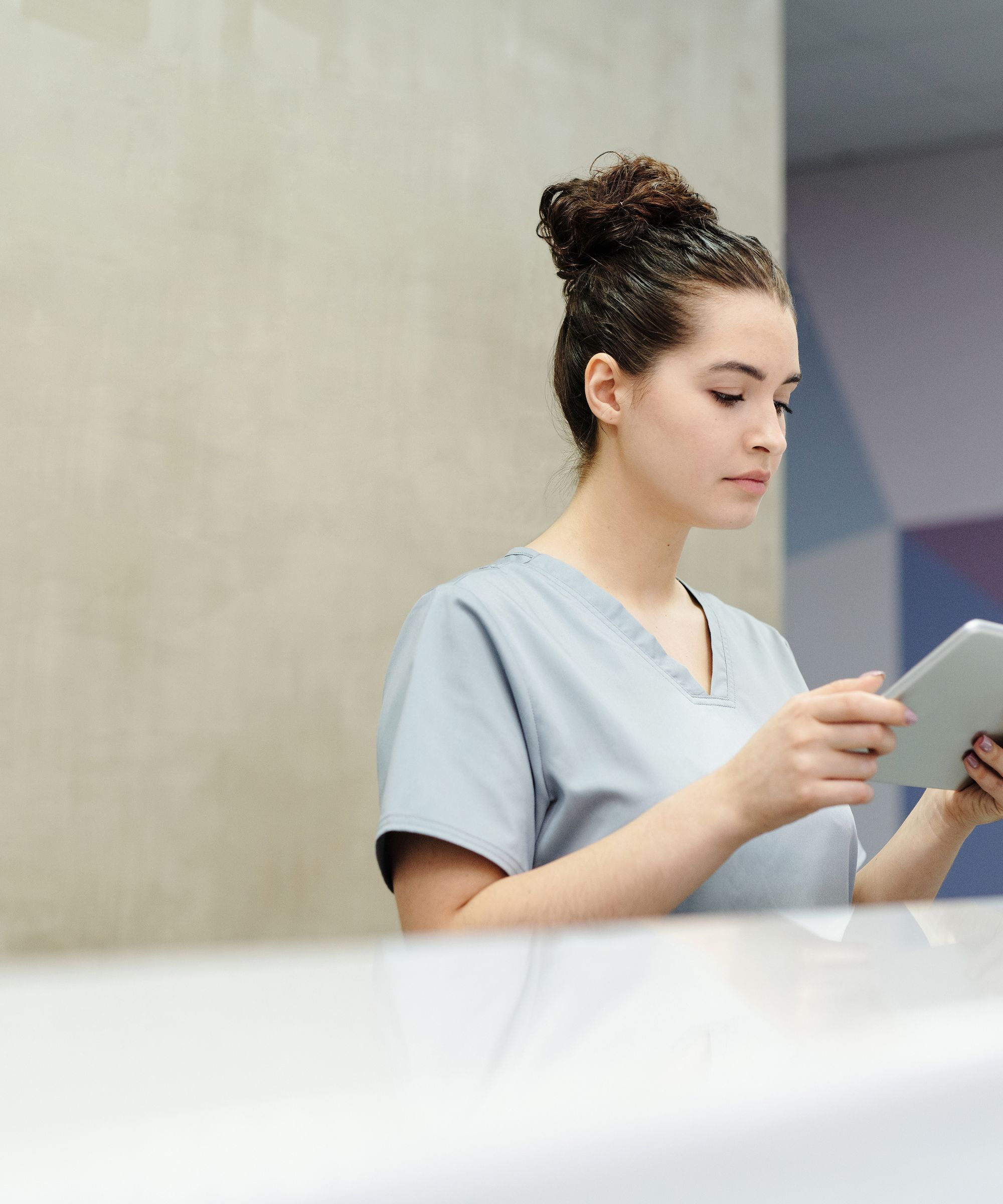 Medical office receptionist assisting a patient at the front desk