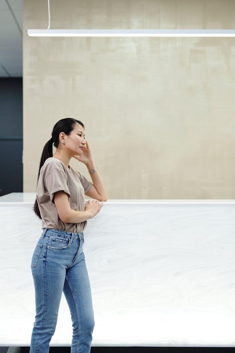 A Young Woman Waiting By A Reception Desk