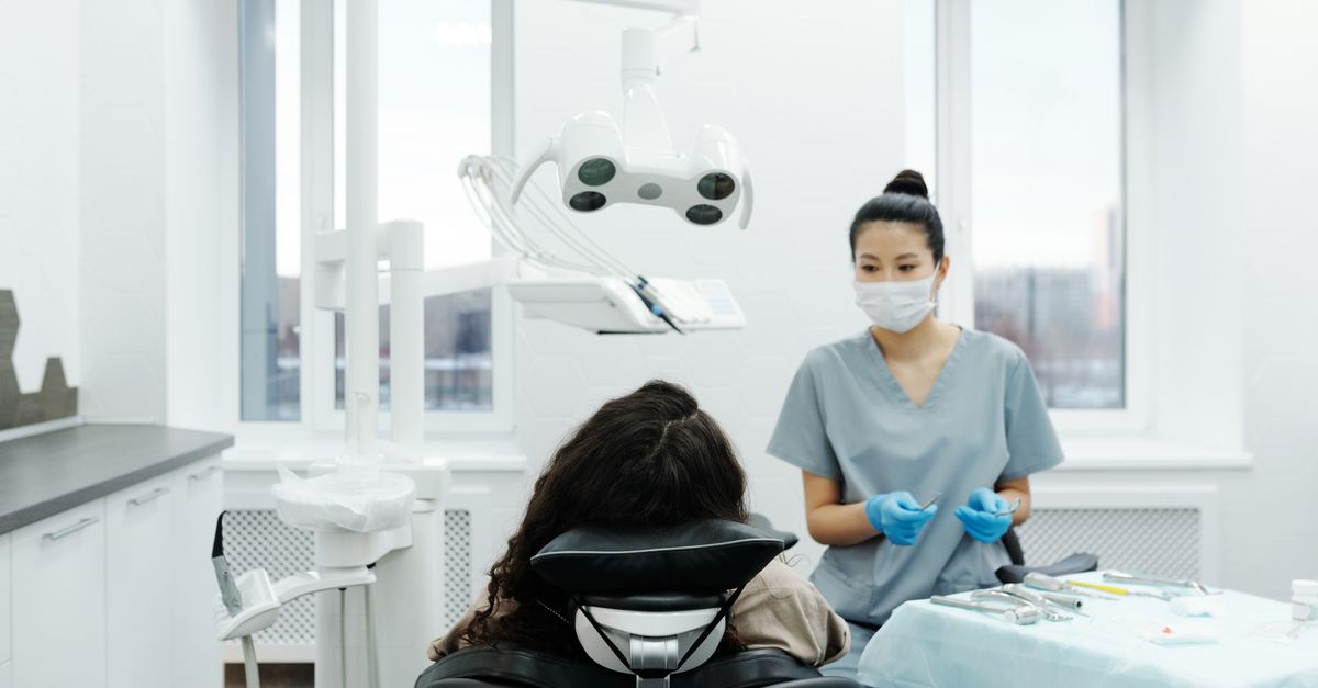 Dentiste avec un patient dans une clinique dentaire moderne effectuant un examen.