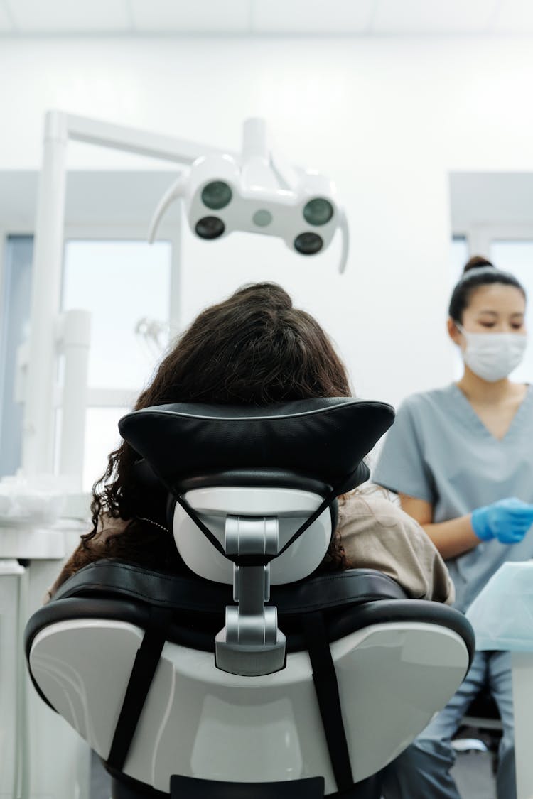 Back View Of A Person Sitting On A Dental Chair