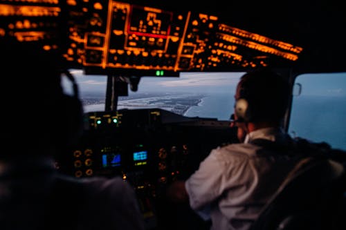 Anonymous pilots in aircraft cockpit flying over sea