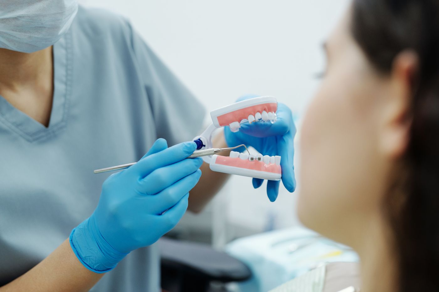 Orthodontiste présentant un modèle avec des bagues dentaires pendant une consultation