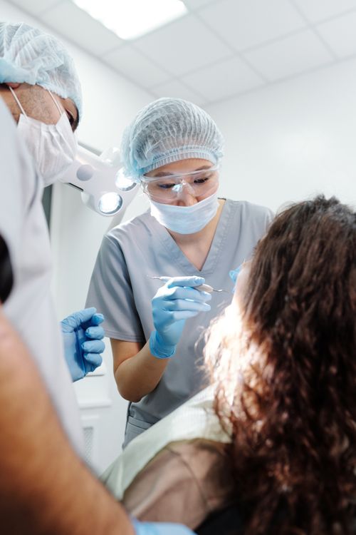 Free Dental professionals examining a patient using specialized tools and equipment in a clinic. Stock Photo