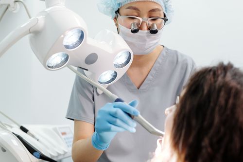 Free Dentist using tools and lights during a dental examination procedure in a modern clinic. Stock Photo