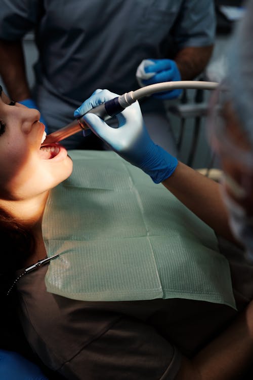 Free A Person Wearing Blue Latex Gloves Checking Patient's Teeth Stock Photo