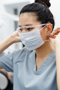 一位亚洲女性医疗保健专业人士在室内调整口罩和护目镜