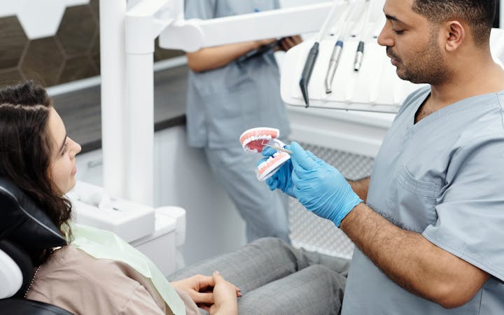 Dentist explains dental procedure to patient in a modern clinic setting.