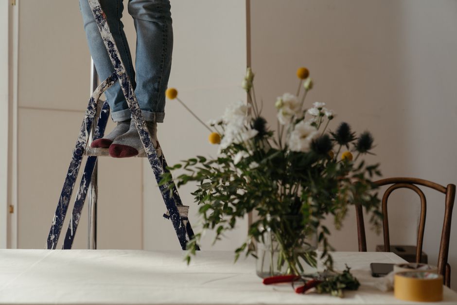 Repurposed Ladder Plant Stand DIY home decor project — A cozy indoor setting featuring a floral arrangement and ladder.