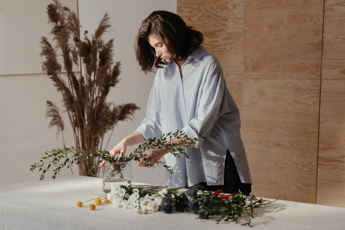 Free Woman in White Robe Holding White Flowers Stock Photo