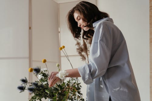 Woman in White Robe Holding White Flowers