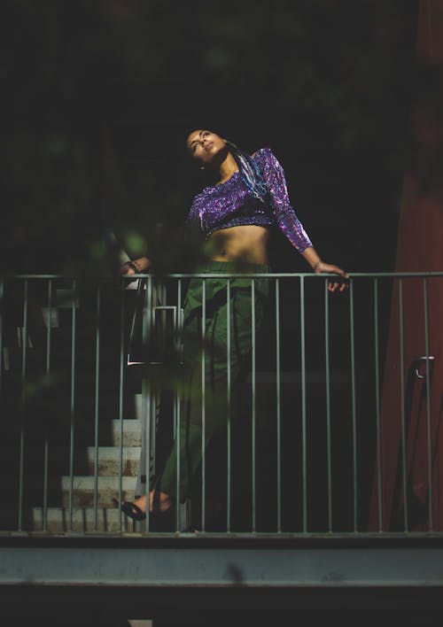 Stylish young ethnic lady resting on balcony